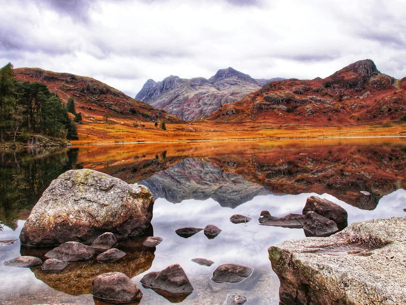 Blea Tarn A Lake With Rocks And Mountains In The Background